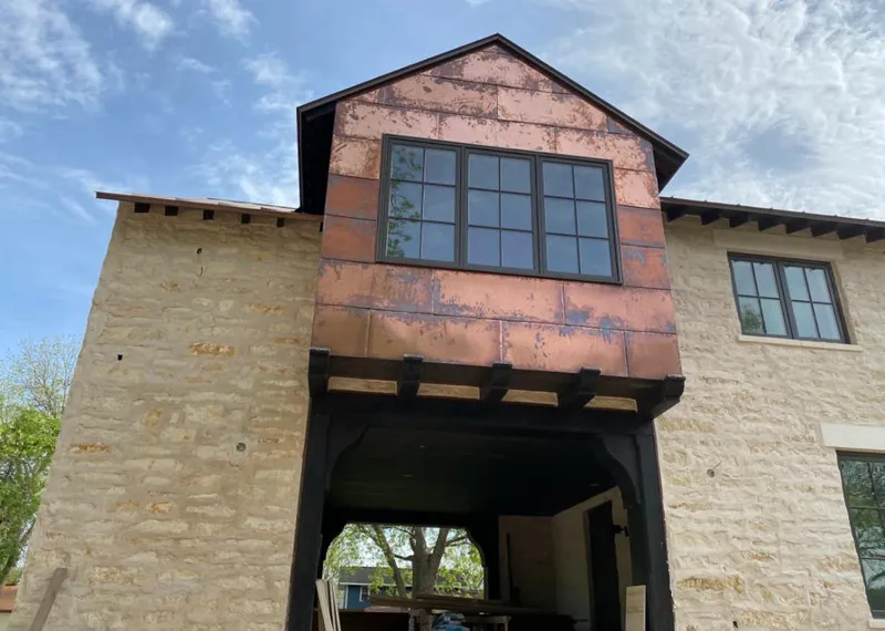 Copper metal panel facade on a stone building for Skylight Installation in Briar